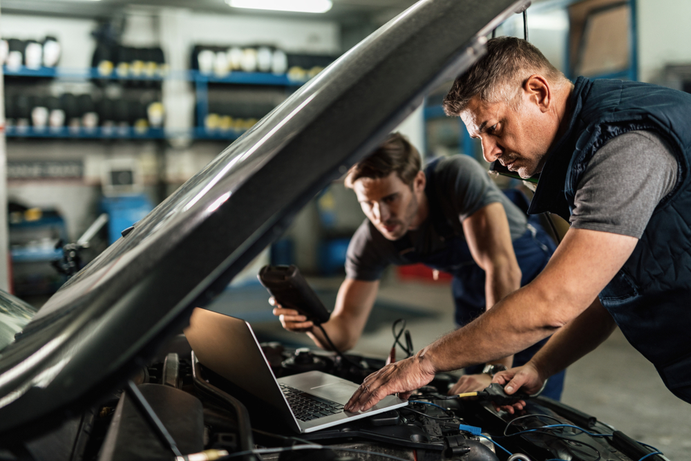 Mechanics performing car computer diagnostics