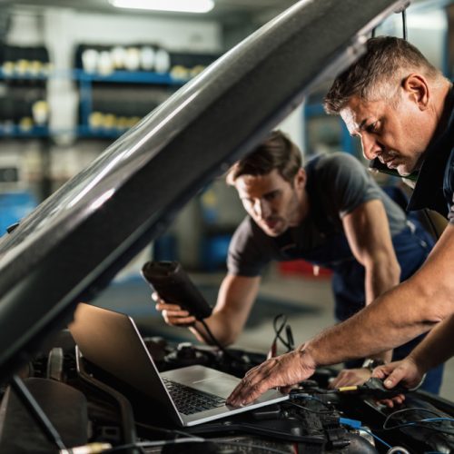 Mechanics performing car computer diagnostics