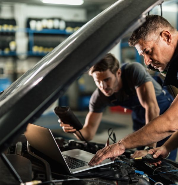 Mechanics performing car computer diagnostics