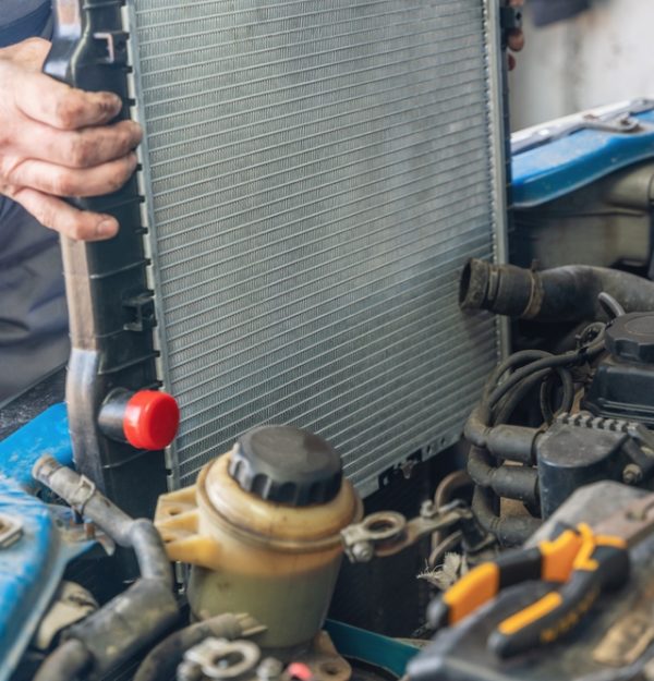 Mechanic installing a new car radiator
