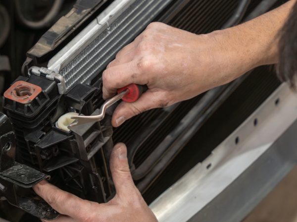 car mechanic repairing radiator