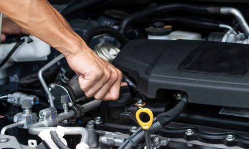 Hand of car machanic checking oil and oil change in car engine and car maintenance in garage. Hand of car machanic checking oil and oil change in car engine and car maintenance in garage.